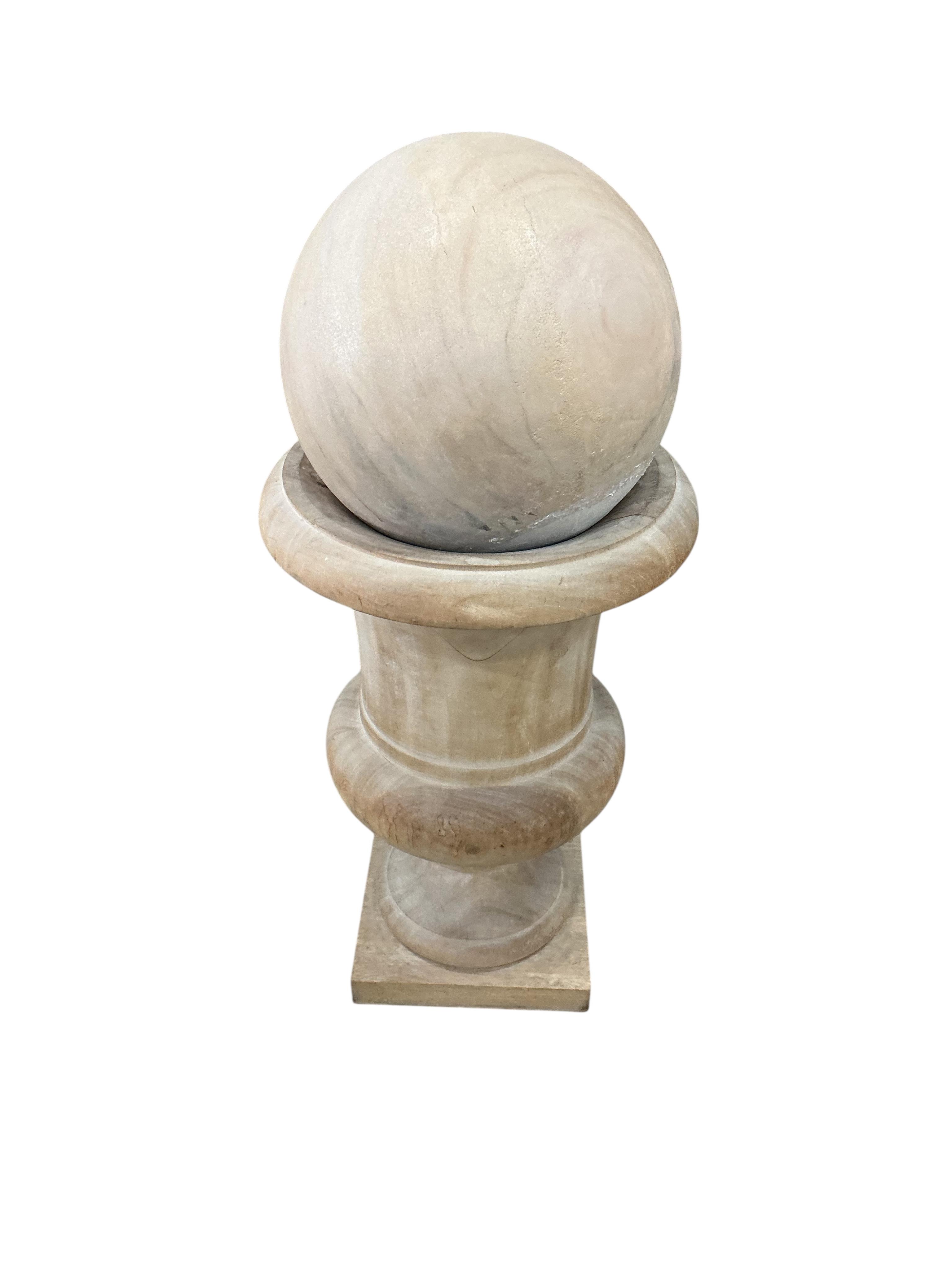 A pair of turned wood urns and composition globes, height 80cm, Provenance: The late Kenneth Turner (1936-2025), celebrity florist, designer and perfume retailer, he received the Royal Warrant from the Prince of Wales in